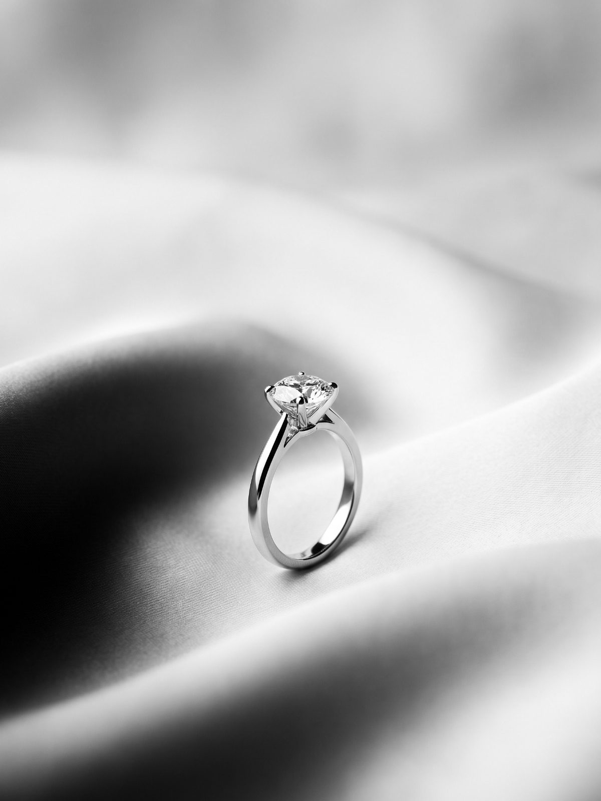Round diamond solitaire engagement ring on ivory silk