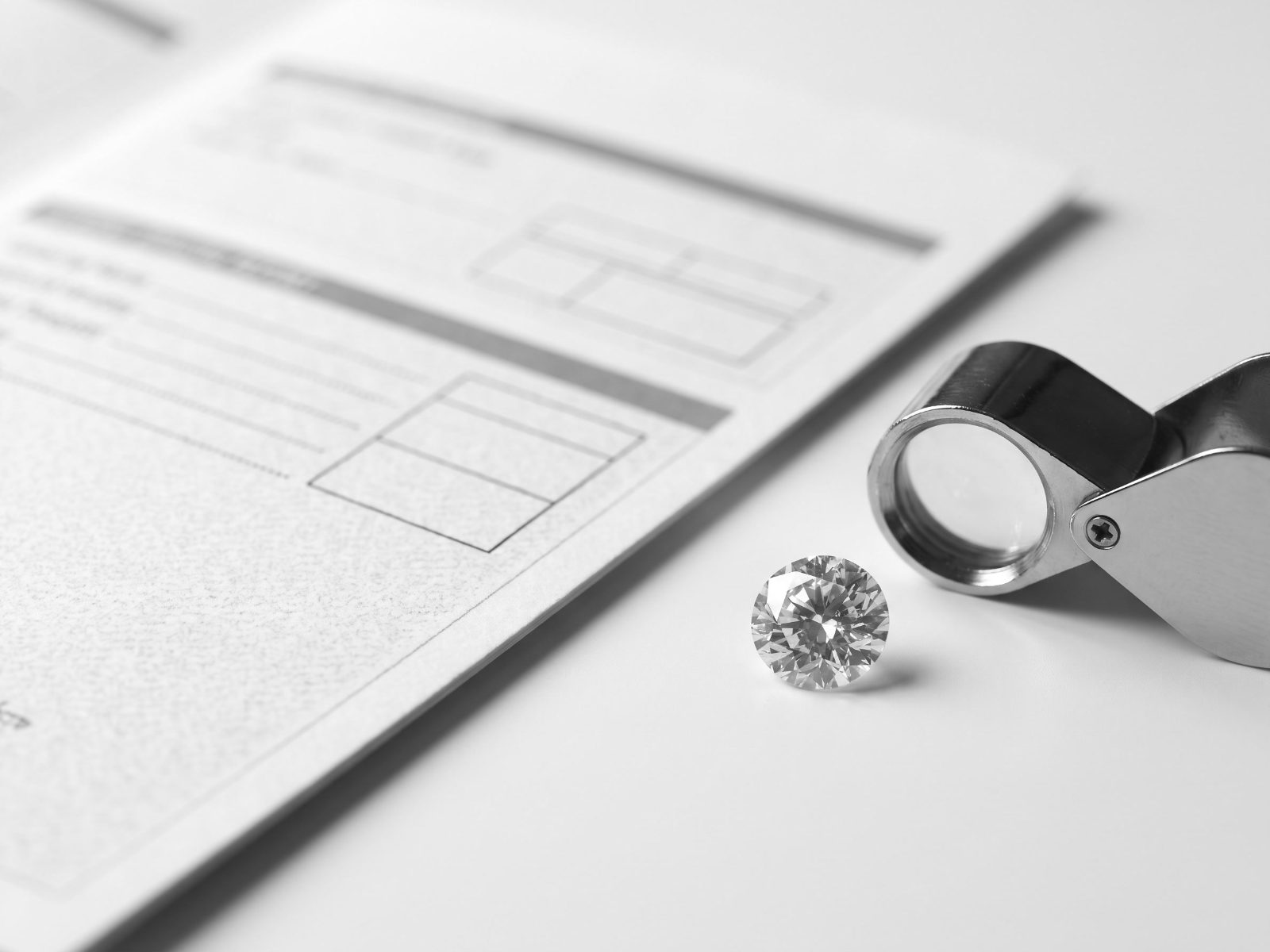 Diamond grading report beside a loose diamond