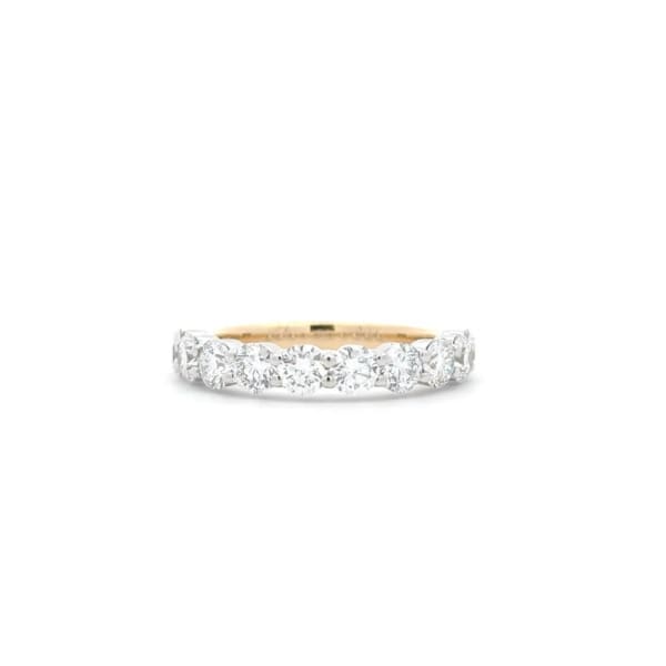 A gold band featuring a series of radiant round diamonds, set against a white backdrop.