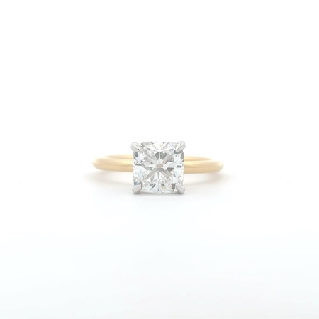 A gold engagement ring with a 2-carat cushion-cut natural diamond and hidden halo is set in a four-prong setting against a plain white background.