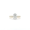 Displayed is the 2ct Oval Solitaire Natural Diamond Engagement Ring, featuring a prominent oval diamond solitaire at its center. The gold band is embellished with smaller diamonds, enhancing its sparkle and elegance. It is set against a simple white backdrop.