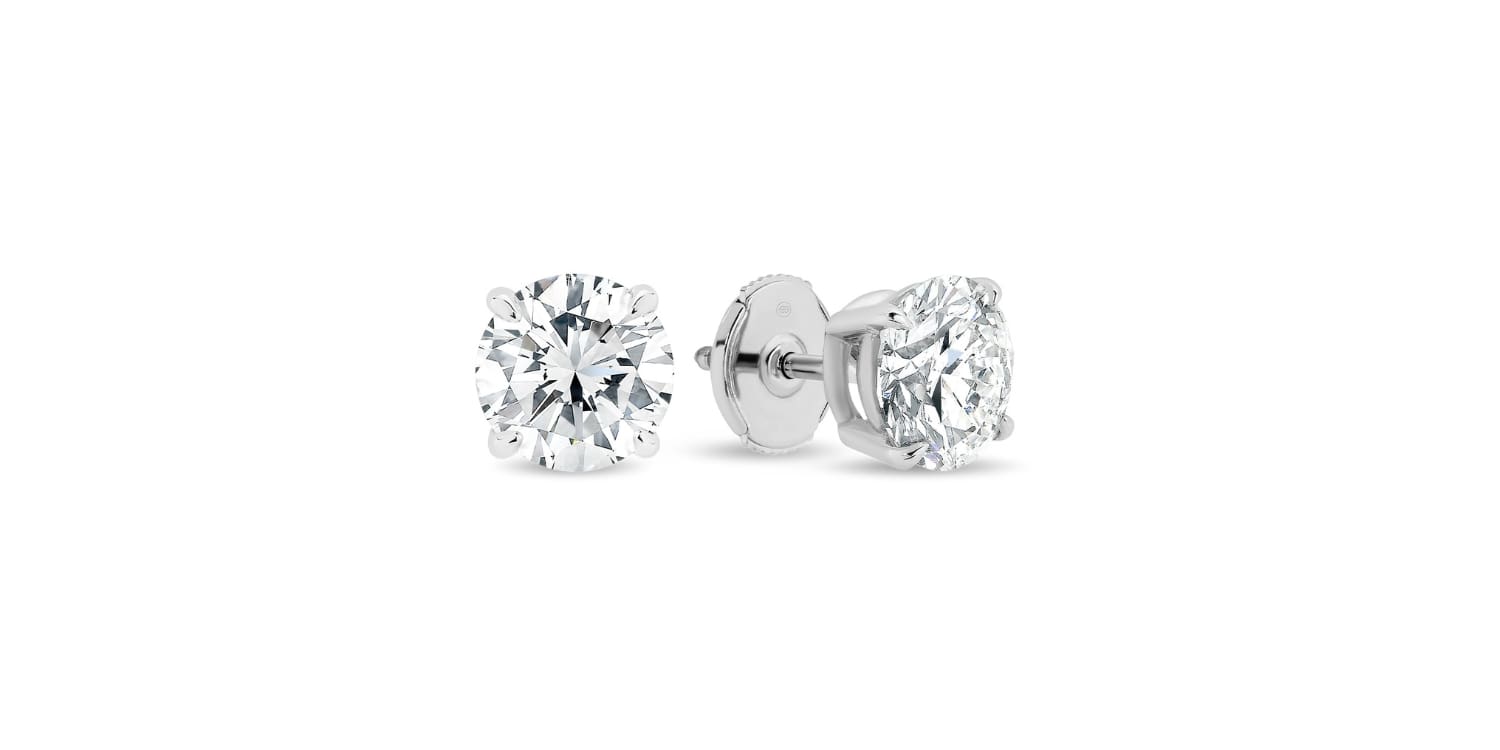 A pair of diamond stud earrings with round, clear diamonds set in a silver metal, displayed on a white background.