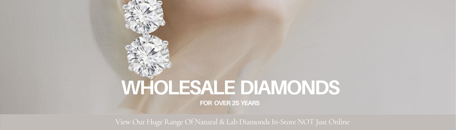 Close-up of two large round diamonds. Text reads, "Wholesale Diamonds for Over 25 Years. View Our Huge Range of Natural & Lab Diamonds In-Store, NOT Just Online." Neutral background.