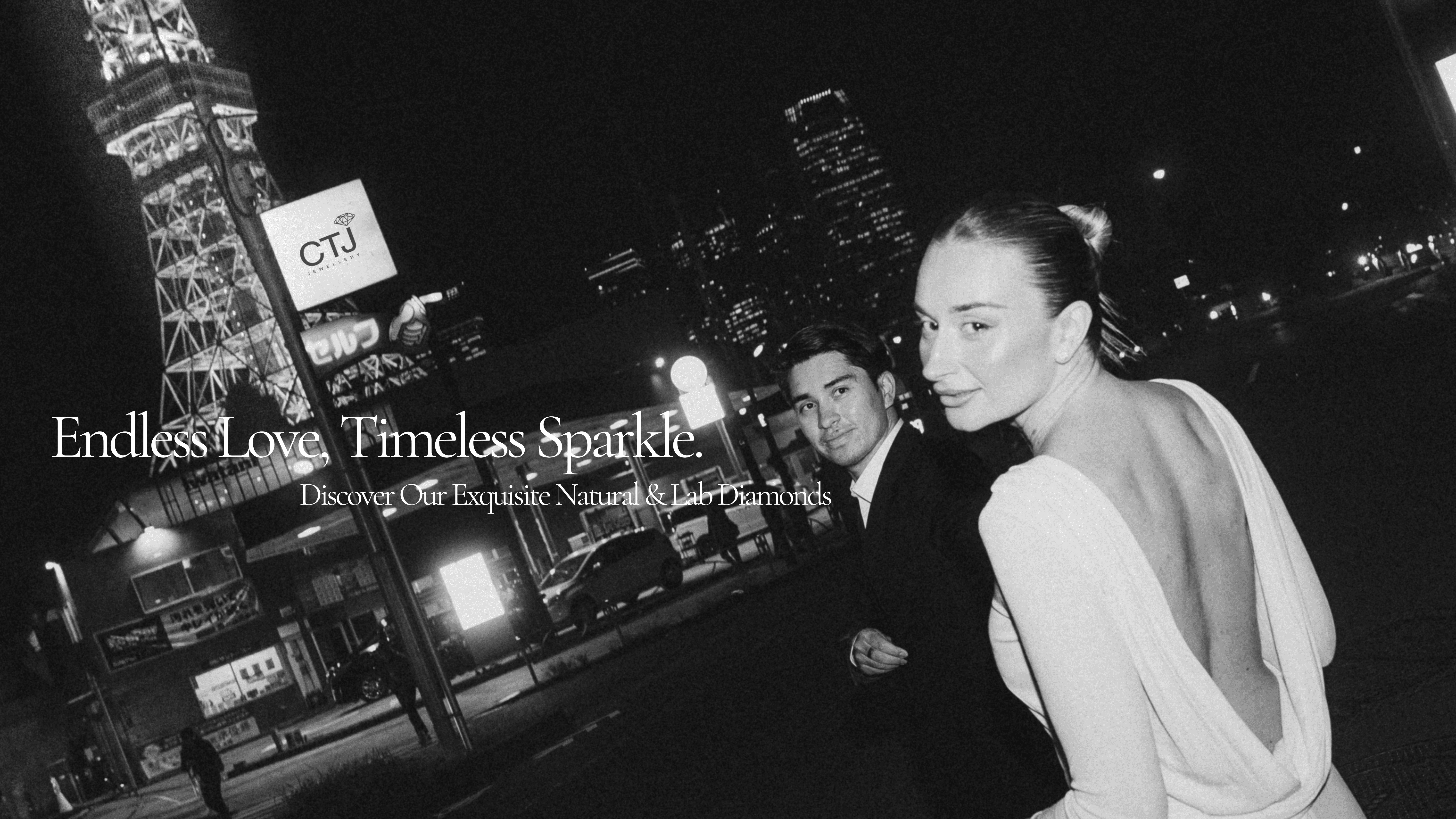 A couple stands in a city scene at night, with city lights and a tower in the background. The woman wears a backless dress, and the man is in a suit. Text reads "Endless Love, Timeless Sparkle. Discover Our Exquisite Natural & Lab Diamonds.