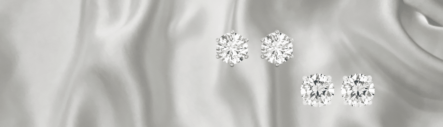 Four pairs of diamond earrings on a silky gray background. The left pair features diamonds set in gold, while the right pair appears in silver settings. The diamonds have a brilliant cut, sparkling under soft light.